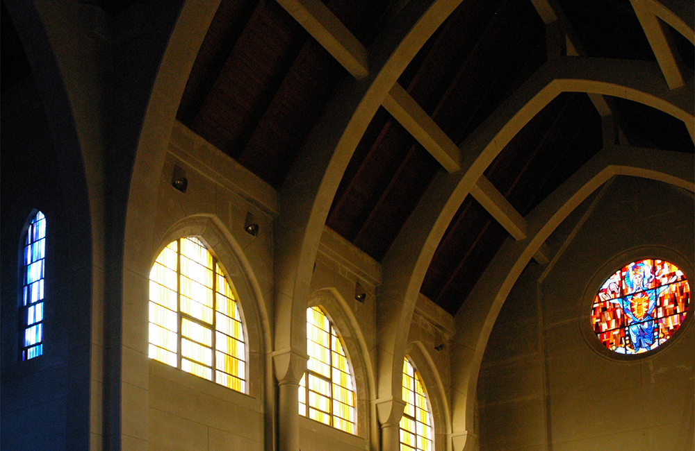 sunlight shining through stainglass windows in church upper level