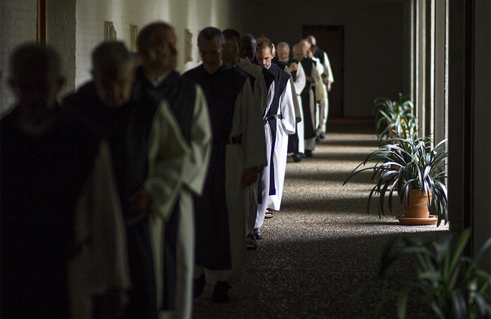 monks process though darkened corridor, Name of Jesus