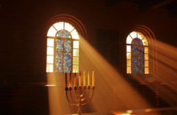 Light shining through stained glass window onto a menorah