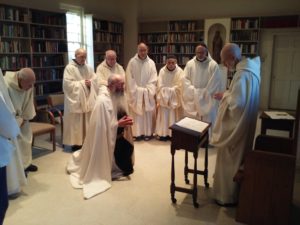 Br. John kneeling before monastic community