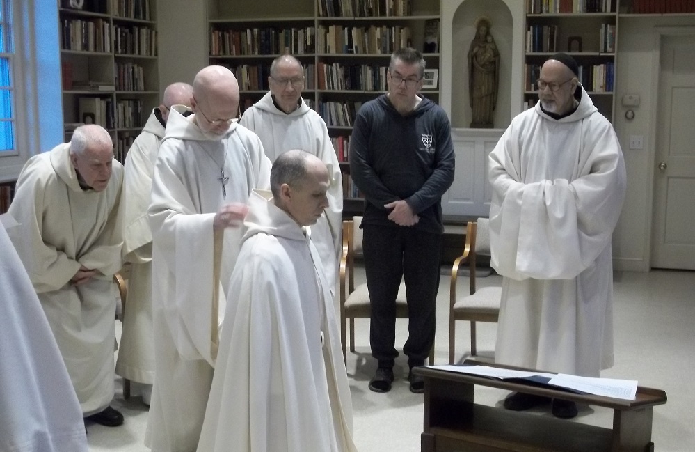 Br. Elijah new novice dressed in white smock prostrate before abbot and monastic community