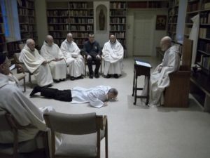 Br. Elijah new novice dressed in white smock prostrate before abbot and monastic community