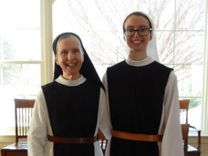 Two nuns in black and white habits smiling and standing side by side