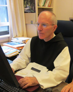 Dom Vincent, abbot of St. Joseph's Abbey at desk working on a computer