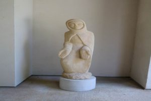 Stone sculpture of Blessed Virgin Mary in cloak with hand held out by artist Dom Hubert Van Zellar