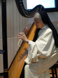 Sister Kathleen playing the harp in habit