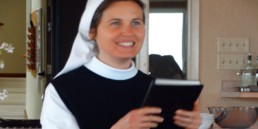 Sr. Madeline's first profession, smiling and holding a book