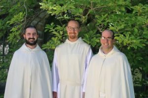 Three smiling Spencer novices in white habits