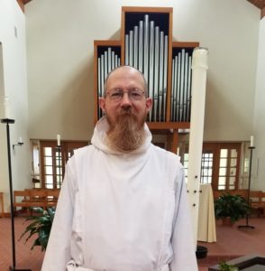 Br. Clement standing in front of Organ at Mepkin Abbey