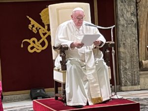 Pope Francis on chair reads remarks to Trappist General Chapter