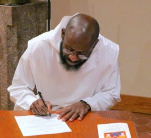 Br. Ambrose signs the vow form