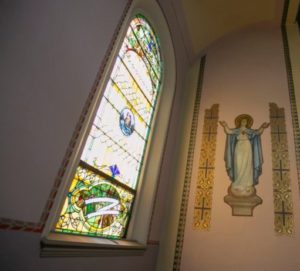 Stain glass window and wall icon of the Blessed Virgin Mary