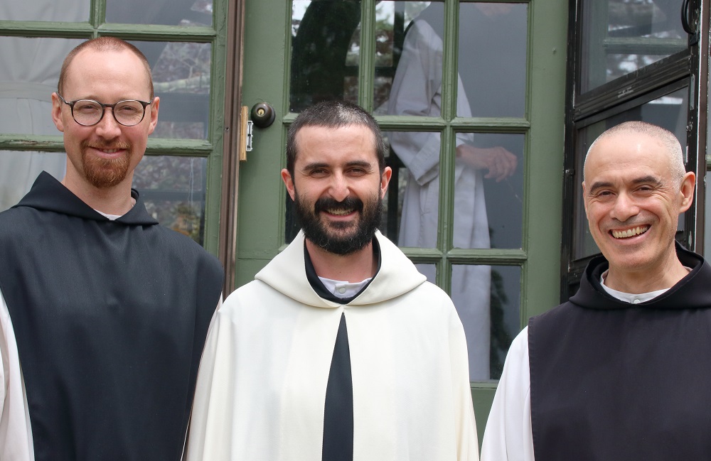 Br. Kenneth smiling between two other monks