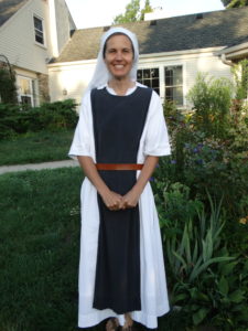 Sister Madeleine smiling in habit in front of building